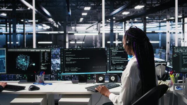 Data center computer scientist using AI assistant to provide user technical support. African american woman in server farm managing live support calls assisted by artificial intelligence, camera A
