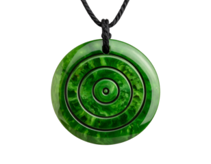 Native Maori greenstone pendant with carved spiral, isolated on a transparent background