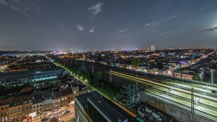 Aerial night timelapse of Brussels North station railway tracks with trains arriving and departing. Belgium