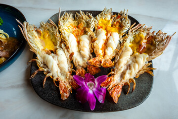 Roasted grilled giant river shrimp or prawn on black plate, Thai style food at a Thailand restaurant.