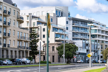 Mixed architectural styles of residential and commercial buildings along a street in Port Melbourne, Australia. Featuring heritage facades alongside modern apartment blocks.