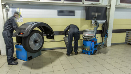 Professional car mechanic replace tire on wheel in auto repair service timelapse.