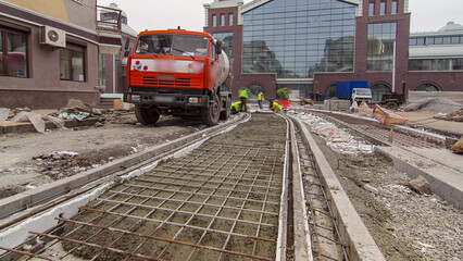 Pouring ready-mixed concrete after placing steel reinforcement to make the road by concrete mixer...
