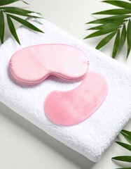 Pink Under Eye Masks on Soft Towel with Tropical Leaves jpg