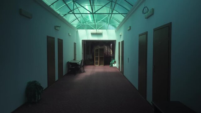 Eerie corridor of an abandoned hotel with flickering lights and liminal atmosphere. A surreal, unsettling space evoking dreamlike emotions.