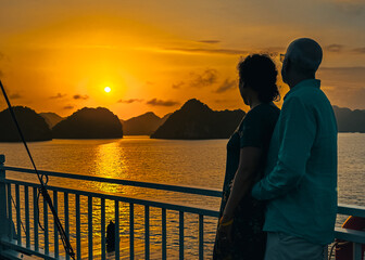 Couple watching the sunset from their cruise ship. Ha Long Bay, Vietnam