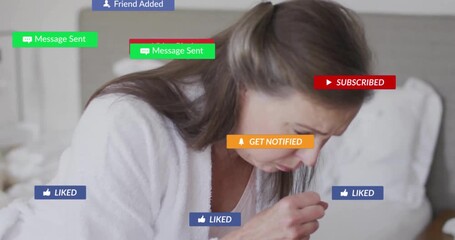 Mature unwell woman coughing into hand on bed, health app alerts appearing then fading around her - Powered by Adobe