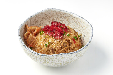 Delicious kimchi fried rice served in ceramic bowl, topped with sesame seeds, green onions, and pickled vegetables, showcasing vibrant and appetizing Korean dish