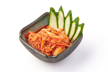 Spicy fermented kimchi served in ceramic bowl with fresh cucumber slices, showcasing traditional Korean side dish with vibrant colors and textures