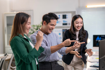 Three people are standing in front of a computer monitor