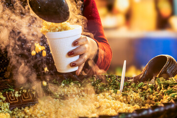 Market vendor serving steaming esquites in mexico city