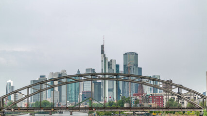 Aerial timelapse of Frankfurt's skyline through the arch of Deutschherrnbrucke Railway Bridge. Germany