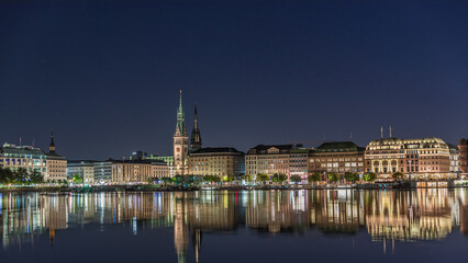 Night timelapse of Binnenalster in Hamburg, Germany, with City Hall and Nikolai Church.