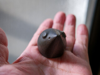 手に乗せた古いネズミ型の文鎮