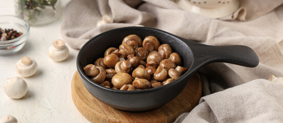 Frying pan with roasted mushrooms on white background