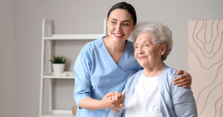 Senior woman with physical therapist hugging at home