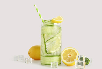 Glass of lemonade with cucumber on white background