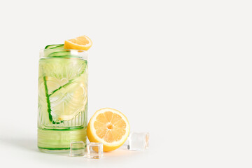 Glass of lemonade with cucumber on white background