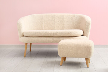 Cozy white sofa and pouf near pink wall