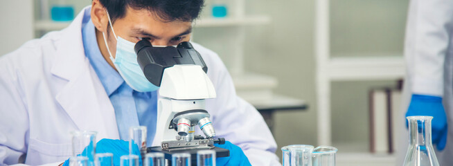 Banner Scientist man look Microscope research in science laboratory. Banner Asian scientist use...
