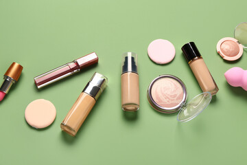 Different decorative cosmetics on green background