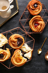 Grids of tasty cruffins with chocolate and jam on black background