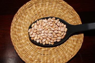 Brazilian food, typical grain present in brazilian culinary. Carioca beans in a spoon.