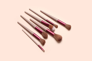 Different makeup brushes on pink background