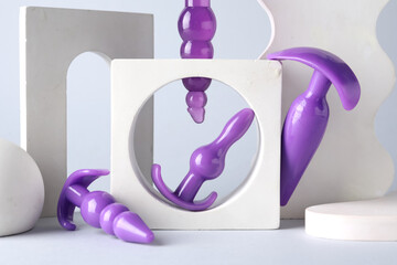 Decorative stands with different sex toys on grey background