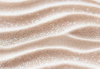 A close-up view of fine, beige sand with gentle ripples and a sparkling texture, evoking a tranquil beach atmosphere. The soft colors enhance a serene and calming mood.