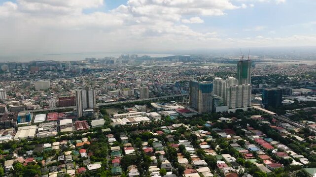 A mix of modern skyscrapers under blue skies in a vibrant urban setting. Metro Manila, Philippines.
