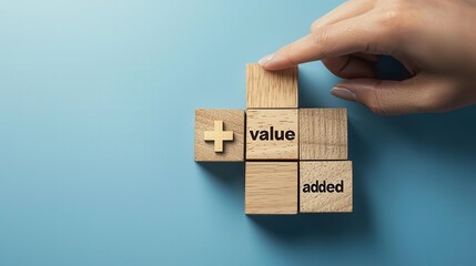 A hand placing a wooden block labeled 'value' onto a blue background, emphasizing the concept of added value in business and personal growth.