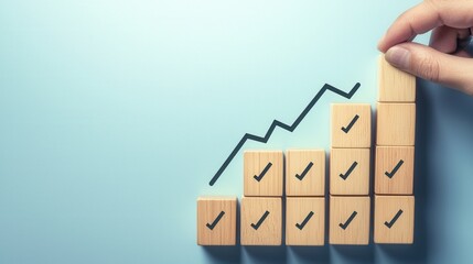 A close-up of a hand stacking wooden blocks to form an upward chart, symbolizing growth and achievement. The background is a soft blue, enhancing the optimistic mood.