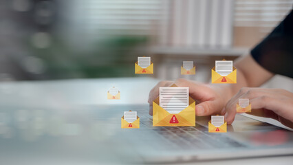 Hands typing on laptop with phishing email alert icons, representing cyber threat, email scam, data breach, and online security awareness in digital communication.