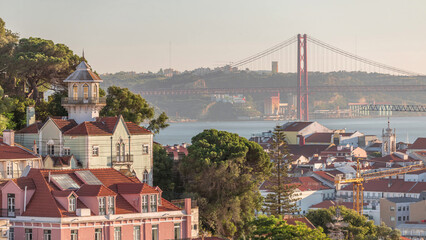Orange Roofs of houses in Lisbon, Tagus River and Bridge April 25 or Ponte 25 de Abril aerial...