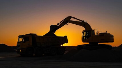 Silhouette of a yellow excavator loading a dump truck with sand against an orange sunset. The scene is calm - Powered by Adobe