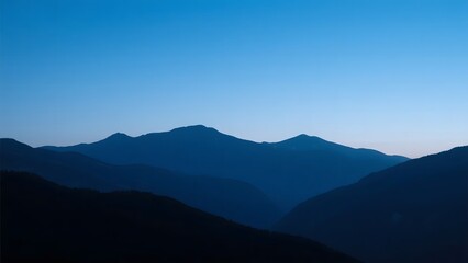 Silhouetted Mountain Ranges Against a Clear Blue Sky