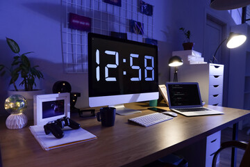 Programmer's desk with computer and laptop in office at night