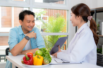 Asian nutritionist using tablet to explaining personalized meal plan with AI to patient during healthcare consultation, healthy lifestyle, woman dietitian showing nutrition plan with AI on tablet.
