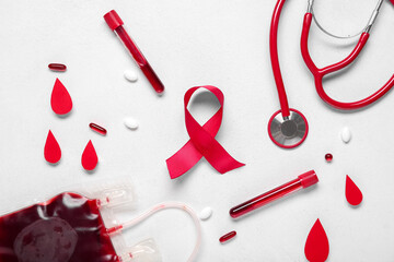Red ribbon with test tubes, drops and stethoscope on white background. Blood Cancer Awareness Month