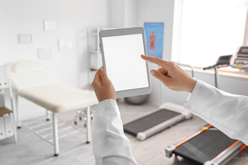 Hands of physiotherapist with blank tablet computer in office, closeup