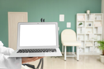 Hands of physiotherapist with blank laptop in office, closeup