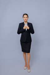 Confident professional woman in formal business attire standing against plain light gray background
