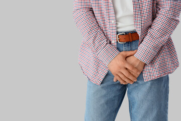 Young man with prostate problem on light background, closeup. Cancer awareness concept