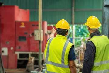 Two professional engineer worker technician assistant in helmet inspection check old machine...