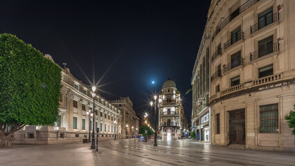 Illuminated Adriatica building on Avenida de la Constitucion at night, Seville, Spain