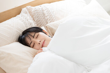 ベッドで寝る女性　