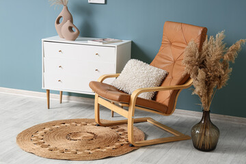 Interior of living room with armchair, pampas grass and commode