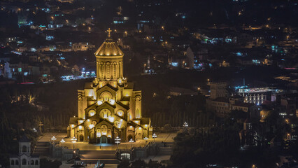 Illuminated Tsminda Sameba Cathedral or Holy Trinity Cathedral of Tbilisi aerial night timelapse. Georgia