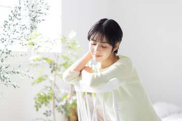 椅子を跨いで座る若い女性